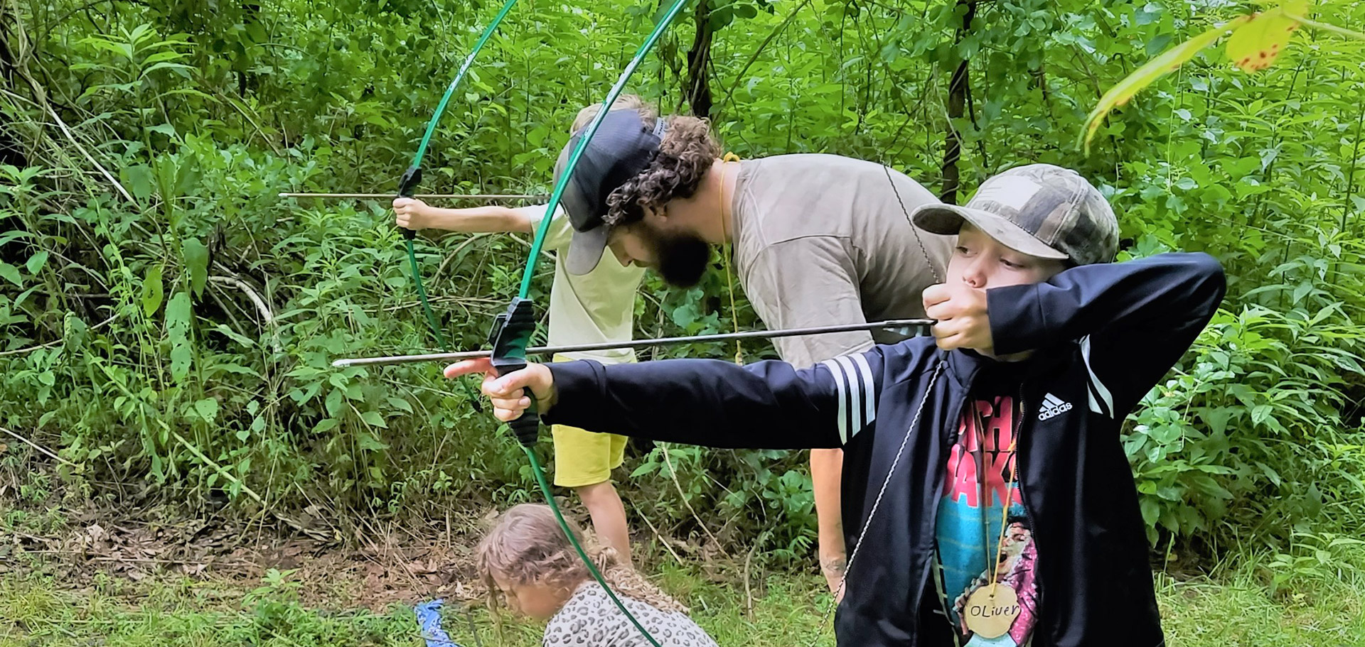 Archery instruction by nature-connection mentor at Forest Floor's Asheville summer camp series