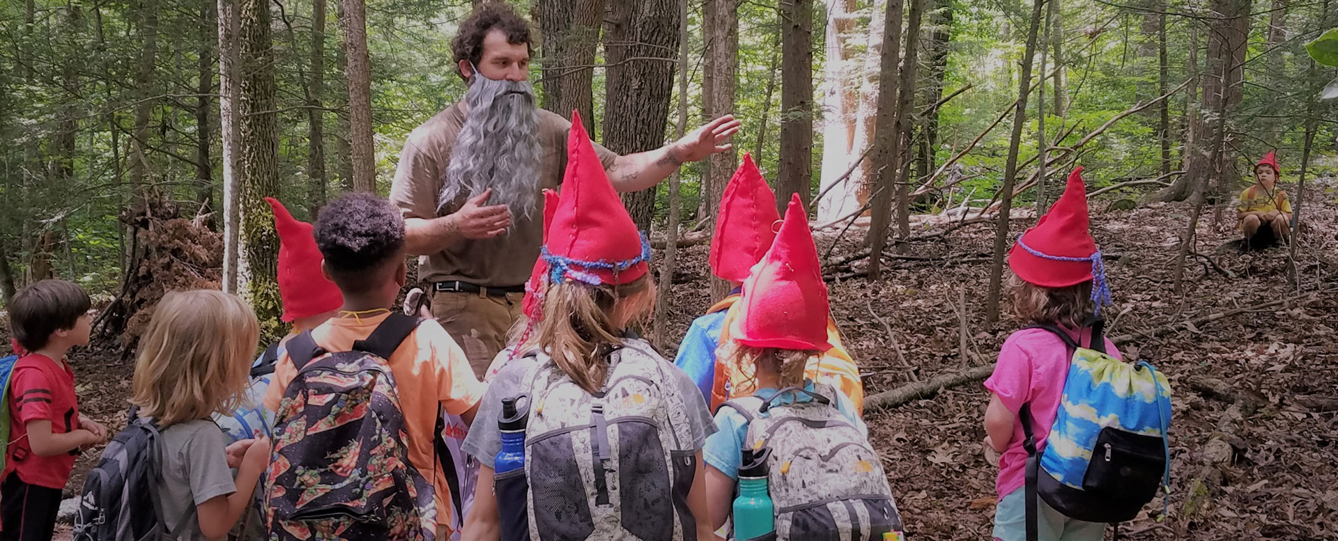 Children in fun hats at Asheville homeschool program in the forest role playing as faeries