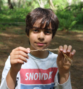 Summer camp student showing rope cordage woven from natural materials