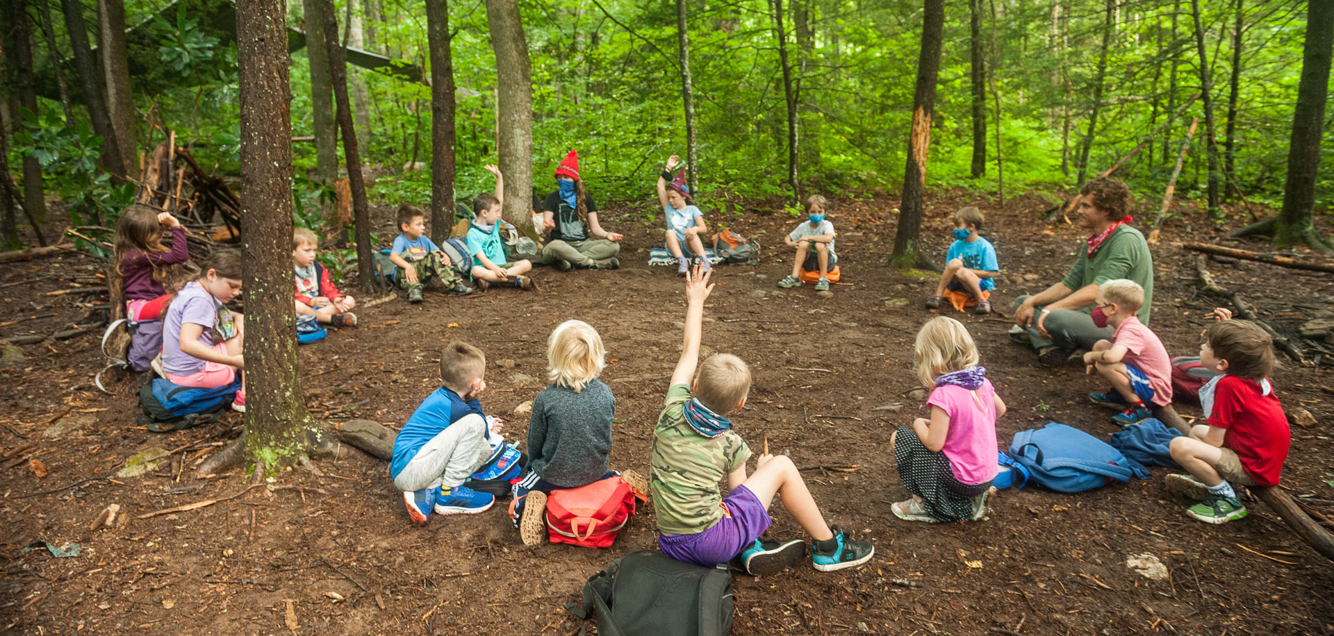 Circle of students learning at nature connection program in Asheville, NC