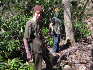 Teenagers at summer camp learning forest stealth and camouflage skills