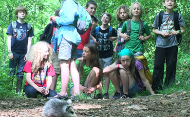 Homeschool kids at forest program with a baby opossum