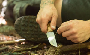 Instructor showing proper handling of knife made at knife-making camp