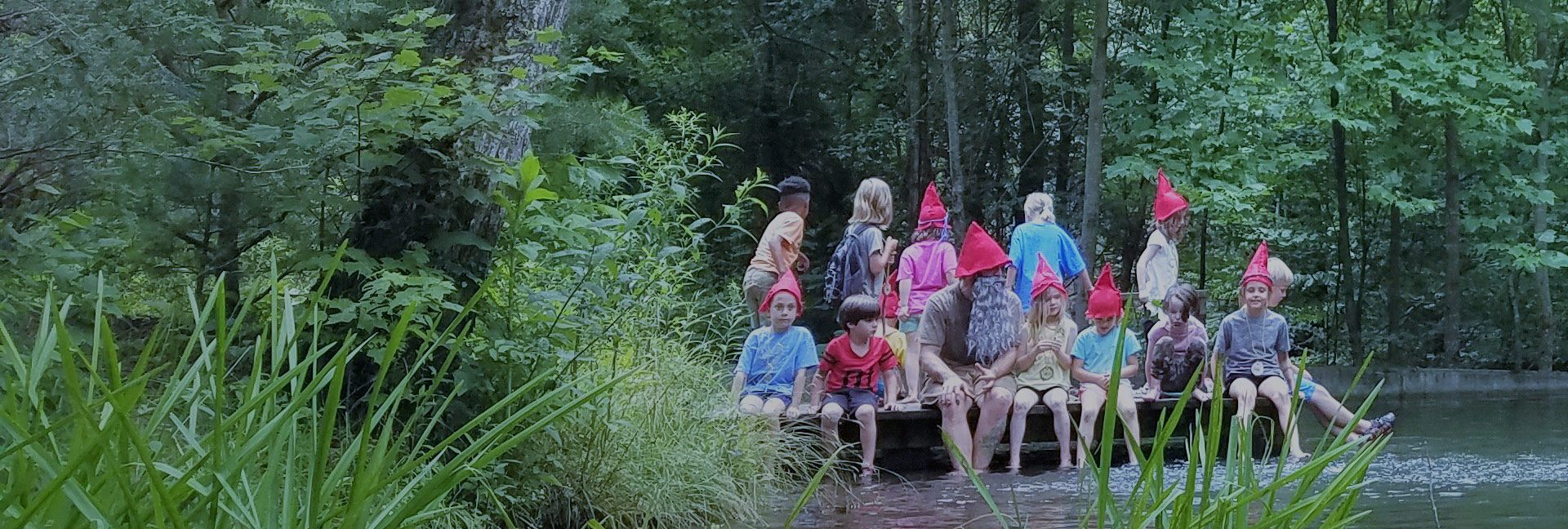 Group of kids on a dock on pond at Asheville nature camp in summer