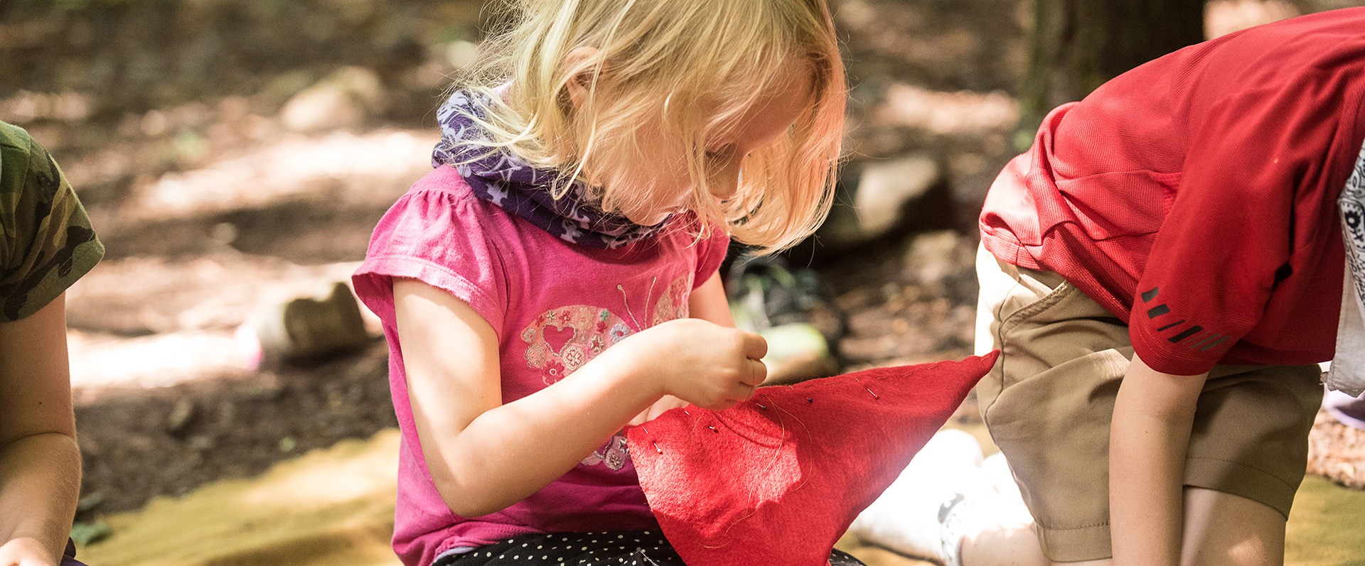 Sewing a felt hat at outdoor crafts summer camp