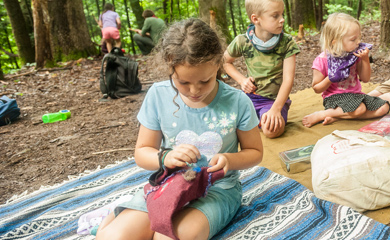 Students doing felting projects in the forest during nature connection camp