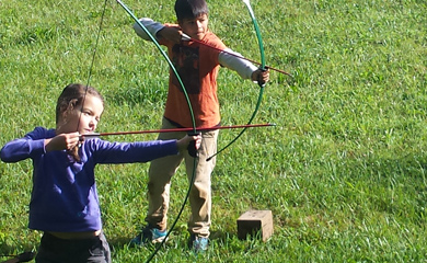 Asheville summer day camp Archery Range with kids learning archery arrows drawn
